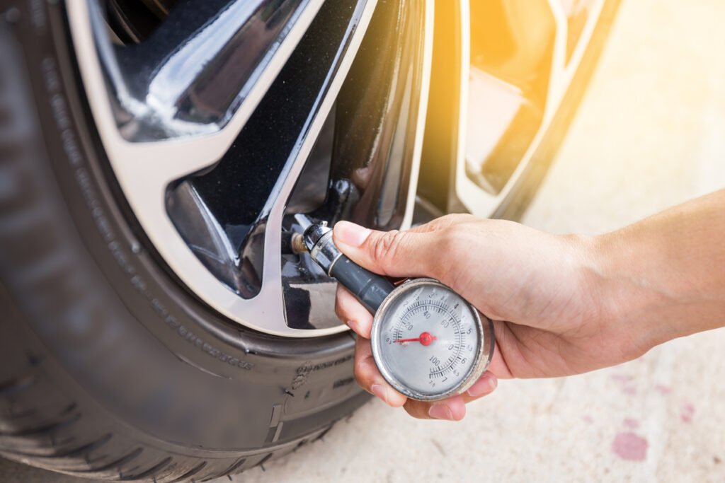 Hand holding pressure gauge for car tyre pressure measurement